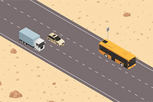 Autobus giallo e camion su una strada nel deserto